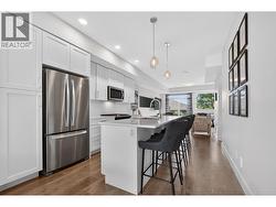 Beautiful kitchen featuring quartz countertops, a large island with bar seating, gas range, abundant cabinetry, and plenty of prep space for cooking and entertaining. - 
