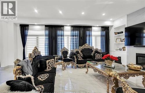 Spacious living area featuring polished tile flooring, recessed ceiling lighting, a built-in media console with open shelving, and a modern fireplace - 137 Diiorio Circle, Ancaster, ON 