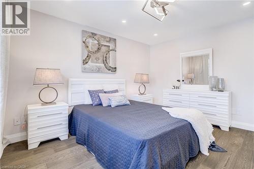 Spacious room featuring wood-finish flooring, recessed lighting, and a contemporary ceiling fixture - 1320 Monmouth Drive, Burlington, ON 