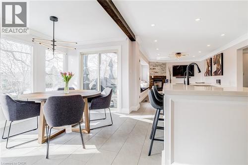 Bright dining area featuring a modern chandelier, large windows, and light-toned flooring - 1320 Monmouth Drive, Burlington, ON 