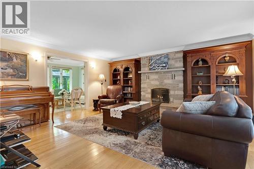 Living area featuring light wood-finish flooring and a stone fireplace with a stone mantel - 110 Grand Ridge Drive, Cambridge, ON 