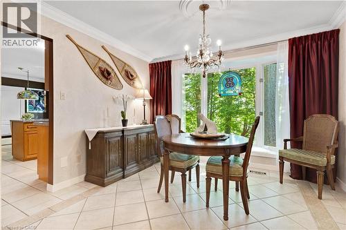 Formal dining area featuring a bay window, decorative chandelier, and crown molding - 110 Grand Ridge Drive, Cambridge, ON 
