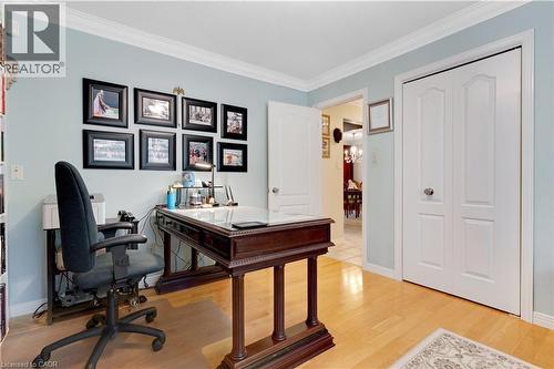 Room with light blue walls, crown molding, wood-finish flooring, and a pair of white paneled bifold doors - 110 Grand Ridge Drive, Cambridge, ON 