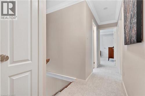 Hallway featuring light neutral wall paint, white trim, crown molding, light-colored carpeting, and recessed lighting - 110 Grand Ridge Drive, Cambridge, ON 