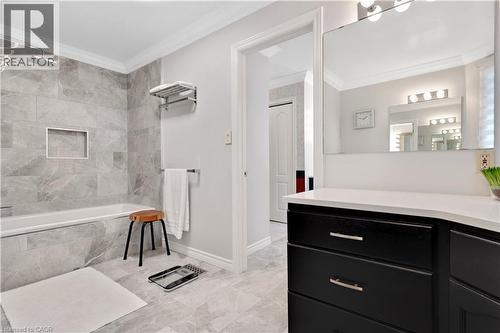 Bathroom featuring a shower-tub combination with gray large-format tile surround, recessed niche, and rain showerhead - 110 Grand Ridge Drive, Cambridge, ON 