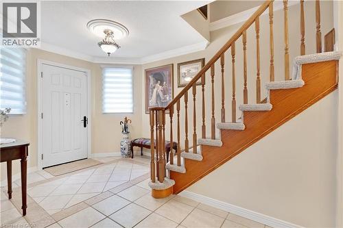 Entryway featuring a paneled door with black hardware, decorative ceiling medallion with an attached light fixture, and tile flooring with a diamond pattern - 110 Grand Ridge Drive, Cambridge, ON 