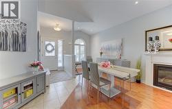 Bright interior showcasing a fireplace with a white mantel, polished wood-finish flooring, and recessed lighting - 