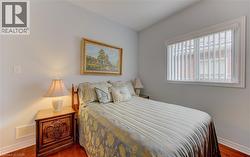Bright room featuring wood-finish flooring, light neutral wall paint, and a window with vertical blinds - 