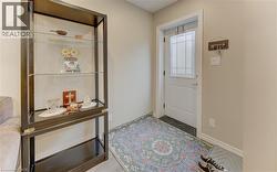 Entryway featuring a white paneled door with decorative glass inserts, dark tile flooring, and light wall paint - 