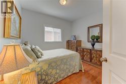 Light-filled room featuring wood-finish flooring, a white window frame, and neutral wall paint - 