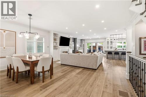 Expansive open-concept living area featuring wood-finish flooring, recessed lighting, and a contemporary chandelier - 336 Newbold Court, Burlington, ON 