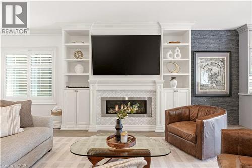 Integrated media wall featuring built-in white cabinetry and shelving - 336 Newbold Court, Burlington, ON 
