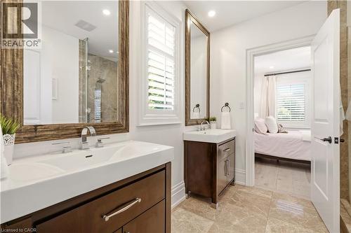 Double vanity with integrated sinks, wood-finish cabinetry, and contemporary chrome fixtures - 336 Newbold Court, Burlington, ON 