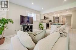 Open-concept living space with white tile flooring, recessed lighting, and white plantation shutters - 
