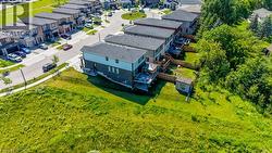 Contemporary multi-story residence featuring a two-tone exterior, dark shingle roofing, and a rear deck - 