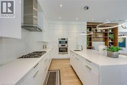 Modern kitchen featuring white high-gloss cabinetry and a spacious center island - 