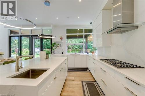 Modern kitchen with white flat-panel cabinetry and a waterfall island featuring an undermount sink - 2104 Devon Road, Oakville, ON - Indoor Photo Showing Kitchen With Upgraded Kitchen