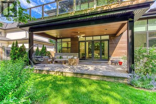 Covered outdoor patio featuring extensive stone paver flooring, a wood-paneled ceiling, and recessed lighting - 2104 Devon Road, Oakville, ON - Outdoor With Deck Patio Veranda