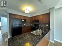 Kitchen featuring wood-finish cabinetry, granite-style countertops, a dark tile backsplash, and a double basin stainless steel sink with a gooseneck faucet - 13 Sorrento Street, Kitchener, ON  - Indoor Photo Showing Kitchen With Double Sink 