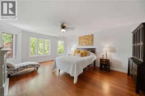 Spacious room featuring rich wood-finish flooring, multiple large windows, and an overhead ceiling fan with integrated lighting - 39 Elodia Court, Hamilton, ON 