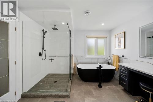 Glass-enclosed shower with matte black fixtures and a stone-finish base - 39 Elodia Court, Hamilton, ON 