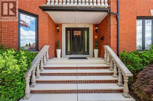 Brick exterior featuring a covered entry, balustrade railings, and symmetrical windows - 39 Elodia Court, Hamilton, ON 