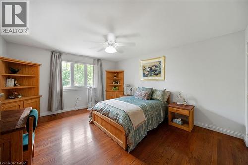 Spacious room featuring rich wood-finish flooring, light grey walls, and a large window with ample natural light - 39 Elodia Court, Hamilton, ON 