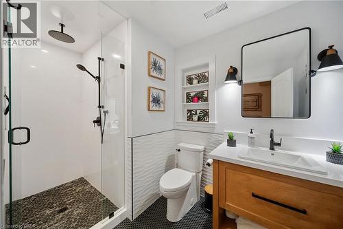 Modern bathroom featuring a glass-enclosed shower with dark tile flooring and matte black fixtures - 39 Elodia Court, Hamilton, ON 