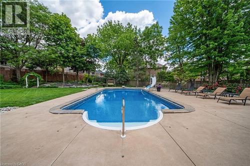 Rectangular swimming pool with a tile surround and concrete decking - 39 Elodia Court, Hamilton, ON 