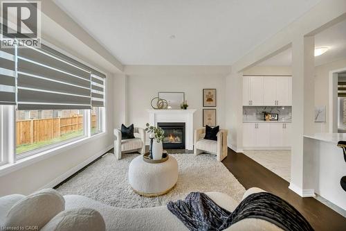 Living room with a glass covered fireplace and light wood-type flooring - 285 Broadacre Drive, Kitchener, ON 