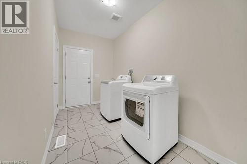 Laundry area featuring light marble finish floors and separate washer and dryer - 285 Broadacre Drive, Kitchener, ON 