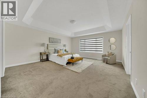 Bedroom featuring a tray ceiling and light carpet - 285 Broadacre Drive, Kitchener, ON 
