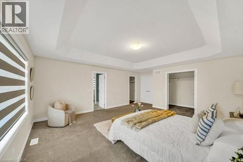 Carpeted bedroom featuring a raised ceiling and a walk in closet - 285 Broadacre Drive, Kitchener, ON 