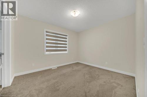 Empty room with a textured ceiling and light carpet - 285 Broadacre Drive, Kitchener, ON 