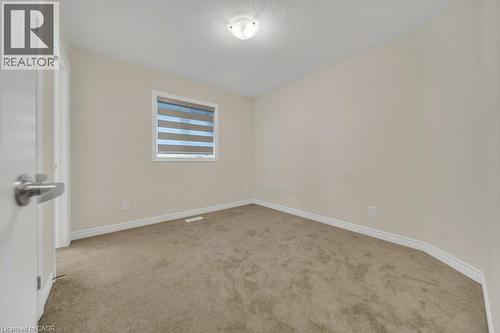 Unfurnished room with light carpet and a textured ceiling - 285 Broadacre Drive, Kitchener, ON 