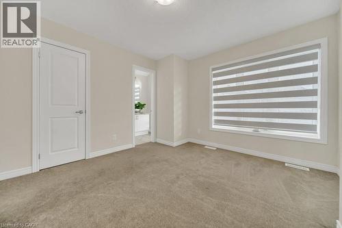 Empty room featuring light carpet and healthy amount of natural light - 285 Broadacre Drive, Kitchener, ON 