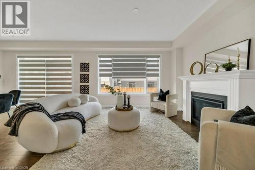 Living room featuring dark wood-style floors and a glass covered fireplace - 285 Broadacre Drive, Kitchener, ON 