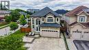 Two-story residence featuring a gray asphalt shingle roof and a stucco exterior with stone accents - 37 Davinci Boulevard, Hamilton, ON 