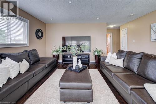 Living area featuring wood-finish flooring, recessed lighting, and a neutral wall color - 37 Davinci Boulevard, Hamilton, ON 