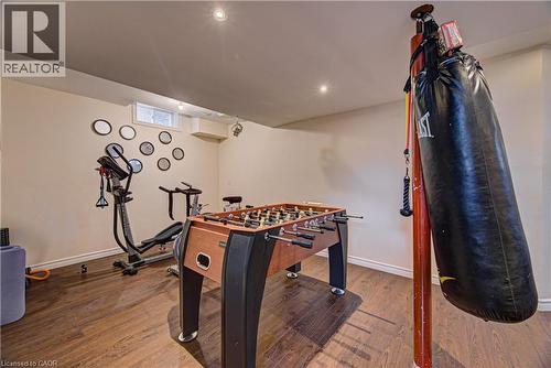Finished basement space with wood-finish flooring, recessed lighting, and a window for natural light - 37 Davinci Boulevard, Hamilton, ON 