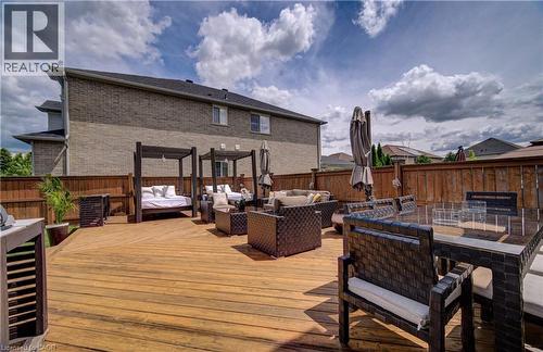 Expansive multi-level wood deck featuring a privacy fence and a two-story brick exterior - 37 Davinci Boulevard, Hamilton, ON 