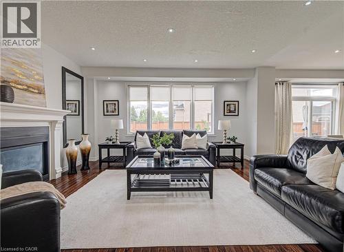 Spacious living area featuring rich wood-finish flooring and recessed lighting - 37 Davinci Boulevard, Hamilton, ON 