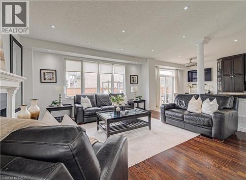 Open-concept living area featuring rich wood-finish flooring, recessed lighting, and expansive windows - 37 Davinci Boulevard, Hamilton, ON 