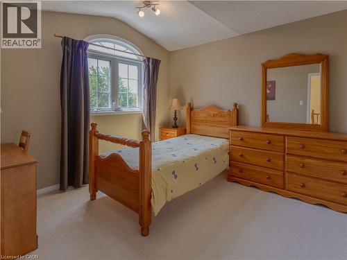 Room featuring a vaulted ceiling with track lighting, an arched top window, and neutral wall tones - 212 Sleaford Street, Waterloo, ON 