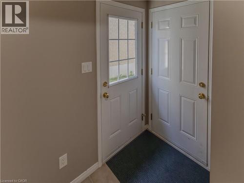 Entryway featuring two white panel doors with brass hardware, one incorporating a gridded glass insert - 212 Sleaford Street, Waterloo, ON 