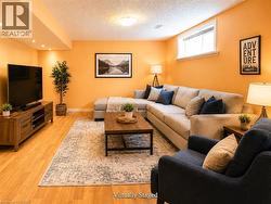 Spacious living area featuring wood-finish flooring, recessed lighting, a window, and a textured ceiling - 