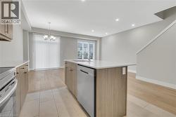 Kitchen with wood-finish cabinetry, white countertops, and stainless steel appliances - 