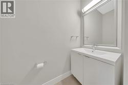 Modern vanity with an integrated sink, polished chrome faucet, and rectangular mirror featuring an overhead bar light - 