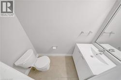 Bathroom featuring a white vanity with integrated sink, chrome faucet, and a large wall-mounted mirror - 