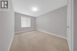 Interior room featuring light gray walls, white trim, and neutral-toned carpeting - 